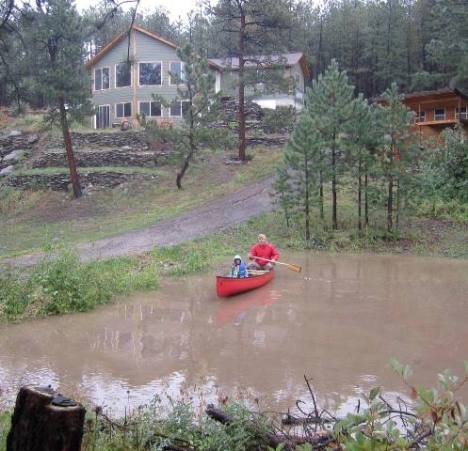 Mark and Lily go canoeing in their soaked neighborhood.