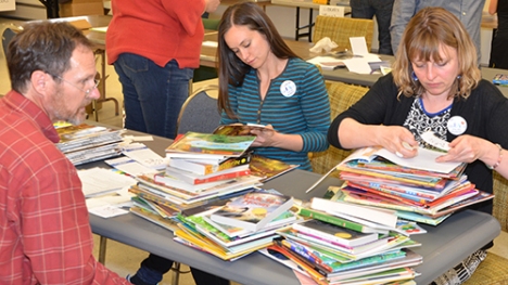 JCEA members Tony Tochtrop, Kimberly Douglas and Mandy Hayes place stickers and bookmarks in donated books.